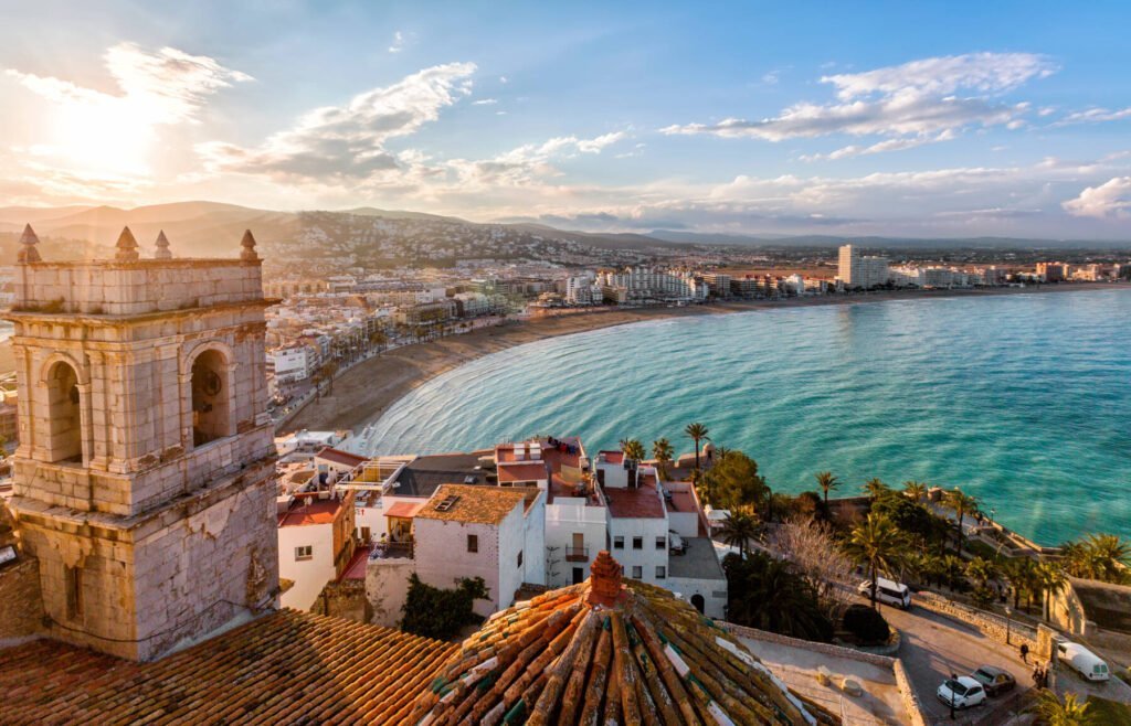 View on Peniscola from the top of Pope Luna's Castle , Valencia, Spain. Uitzicht vanaf een historische stenen toren op de baai, het zandstrand en de kustlijn van Peñíscola.